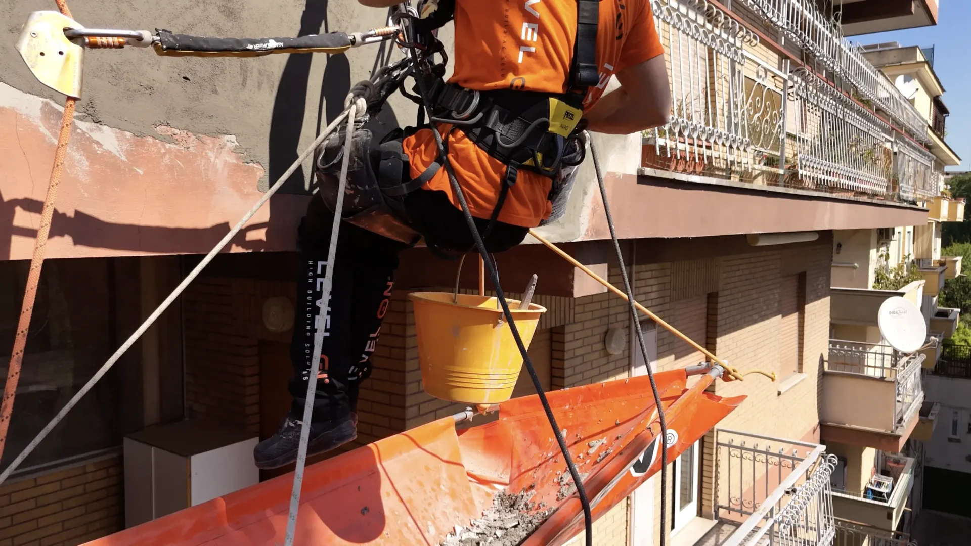 Técnico de Level On trabajando en la fachada de una comunidad de propietarios con sistema de anclaje y acceso por cuerda.