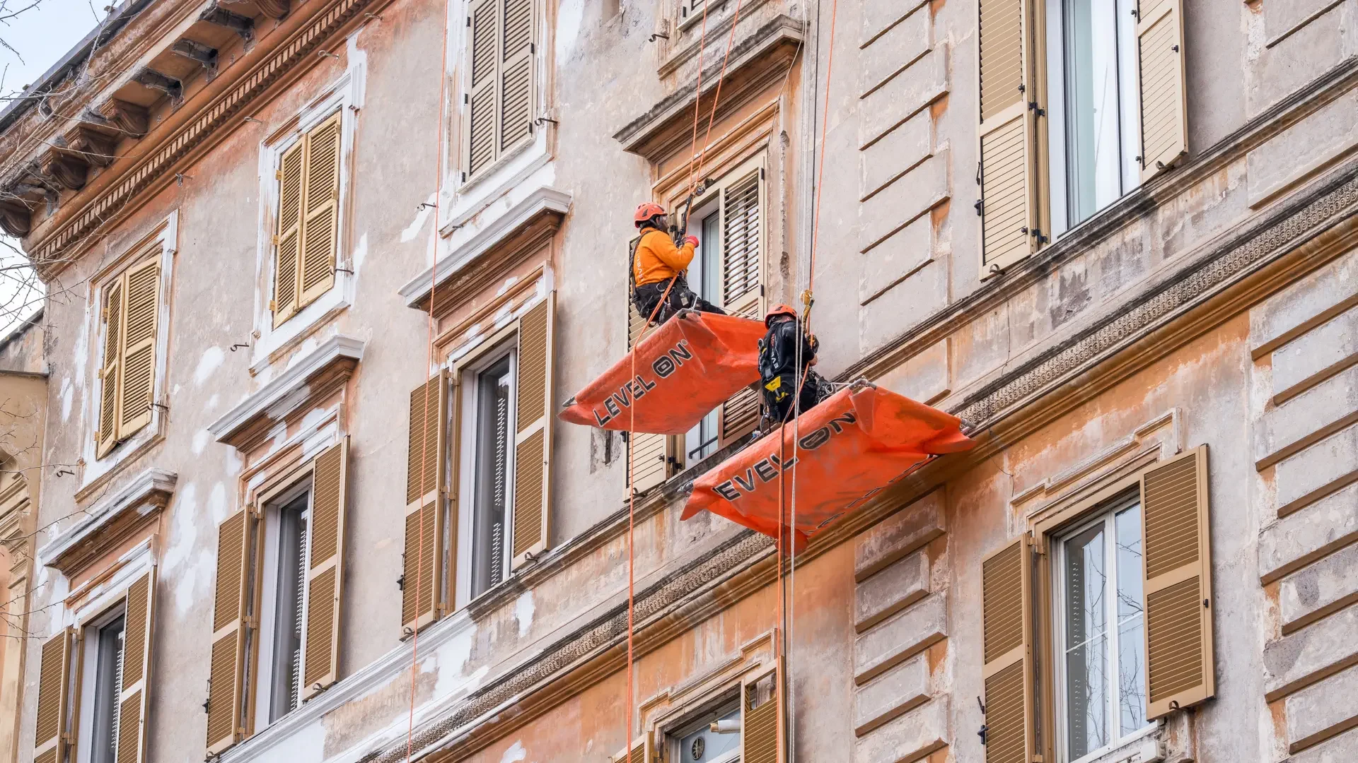 Dos técnicos de Level On realizan trabajos verticales de rehabilitación en una fachada mediante acceso por cuerda.